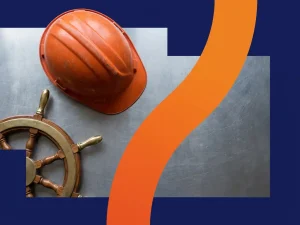 Verweerde bouwhelm naast glanzend scheepsstuur op gepolijst stalen oppervlak, marineblauw met oranje accent, bovenaanzicht.