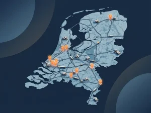 Kaart van Nederland met oranje locatiepinnen in logistieke regio's, miniatuur magazijnen en vrachtwagens verspreid over het landschap.